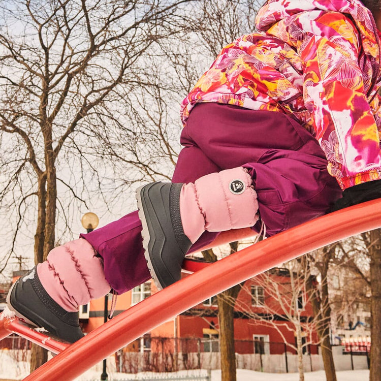 Child climbing outdoors in Kamik winter boots with snow on the ground